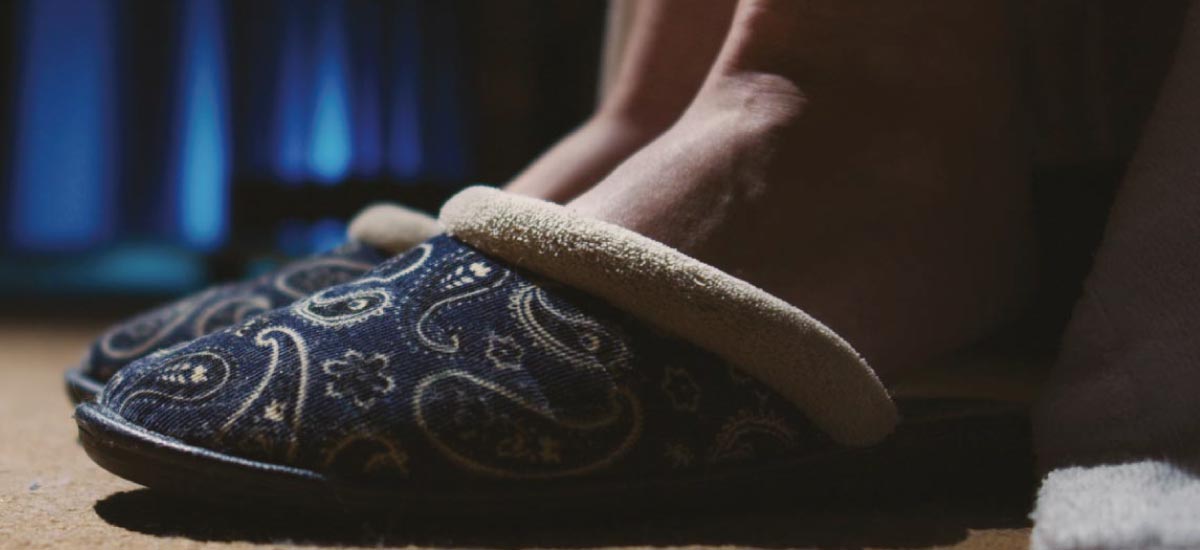 Person wearing slippers in a dark room at night