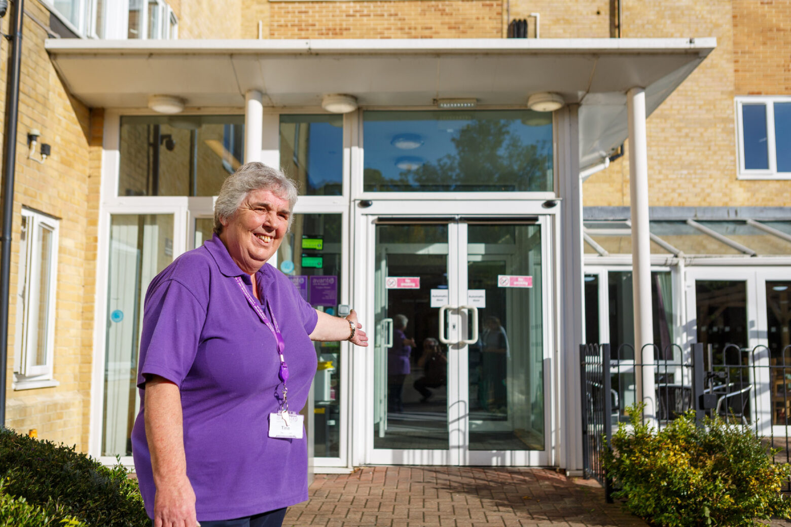 Carer standing outside care home entrance
