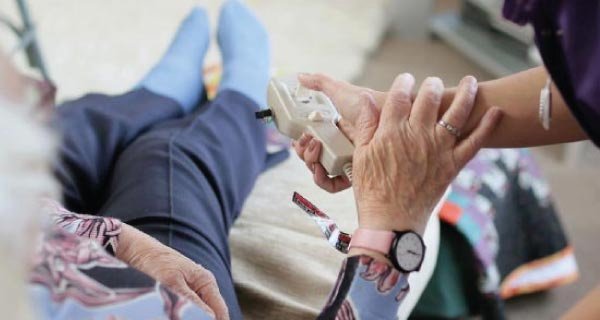 Home carer helping a service user with mobility