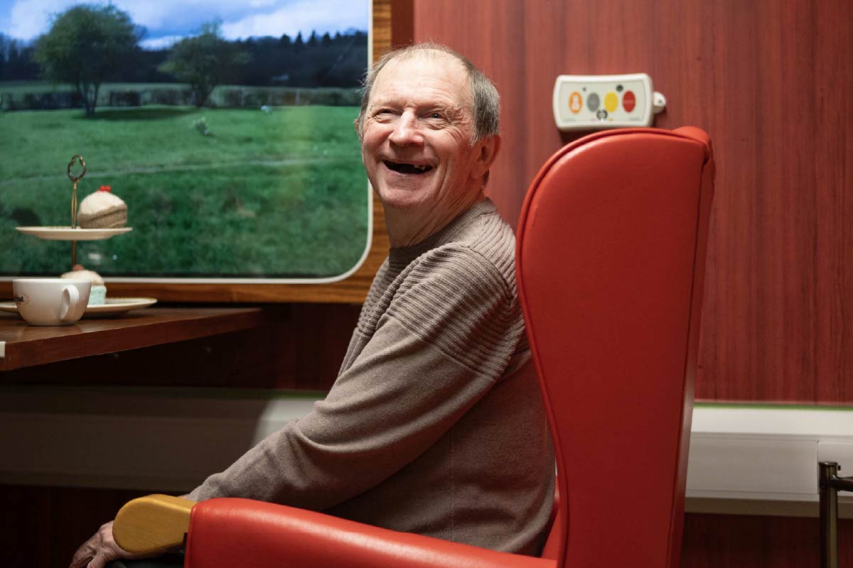 Resident in the railway sensory experience room smiling