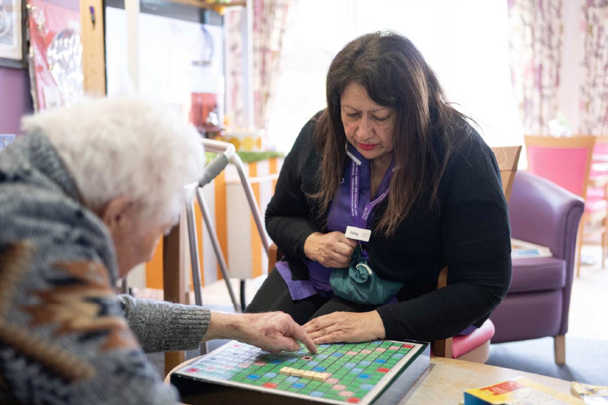Residents and Avante Carer playing Scrabble together