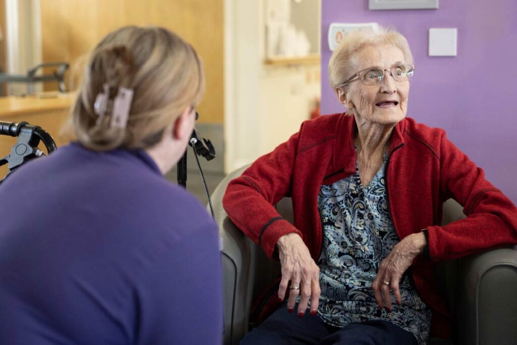 Avante Care and Resident sitting on lounge chairs and talking