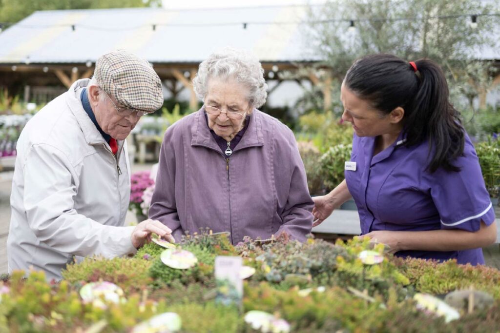 Residents and Avante Care Worker at a garden centre looking at plants and flowers