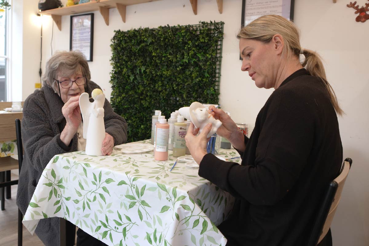 Service user and Home Carer painting pottery