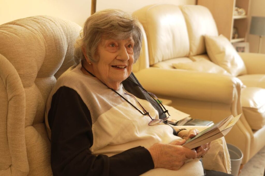 Service user reading a book in her home