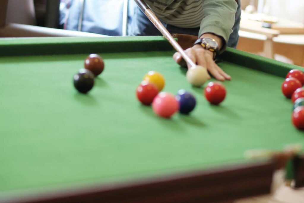 A resident playing a game of pool